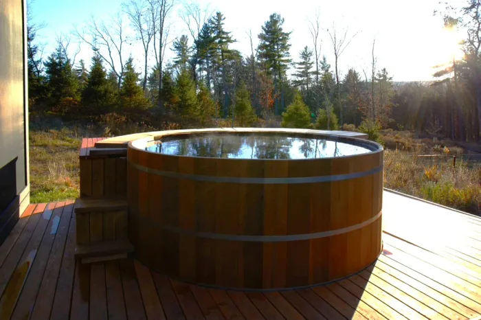 Cedar hot tub beside a backyard studio retreat