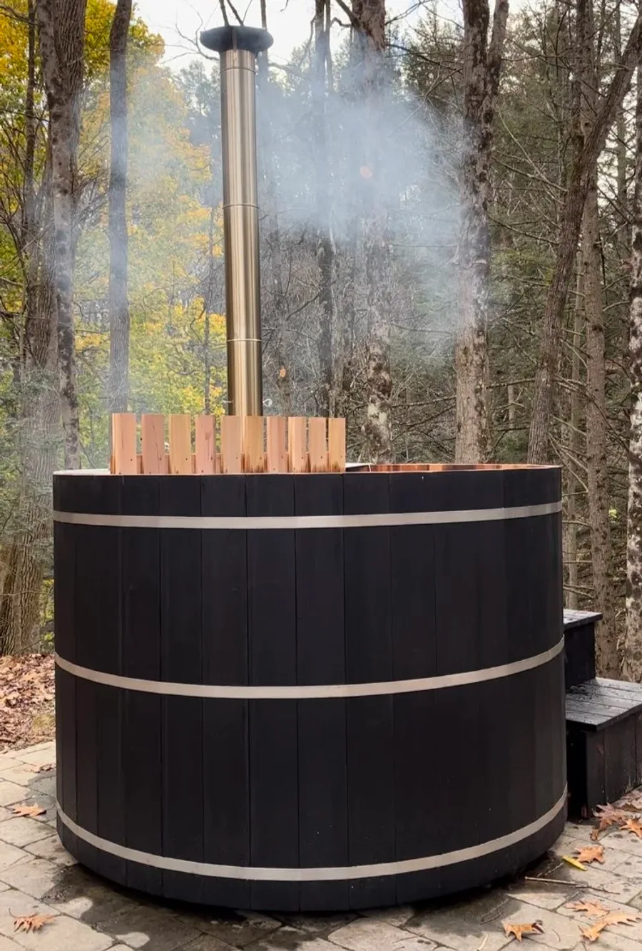 Charred black shou sugi ban cedar hot tub in autumn foliage setting